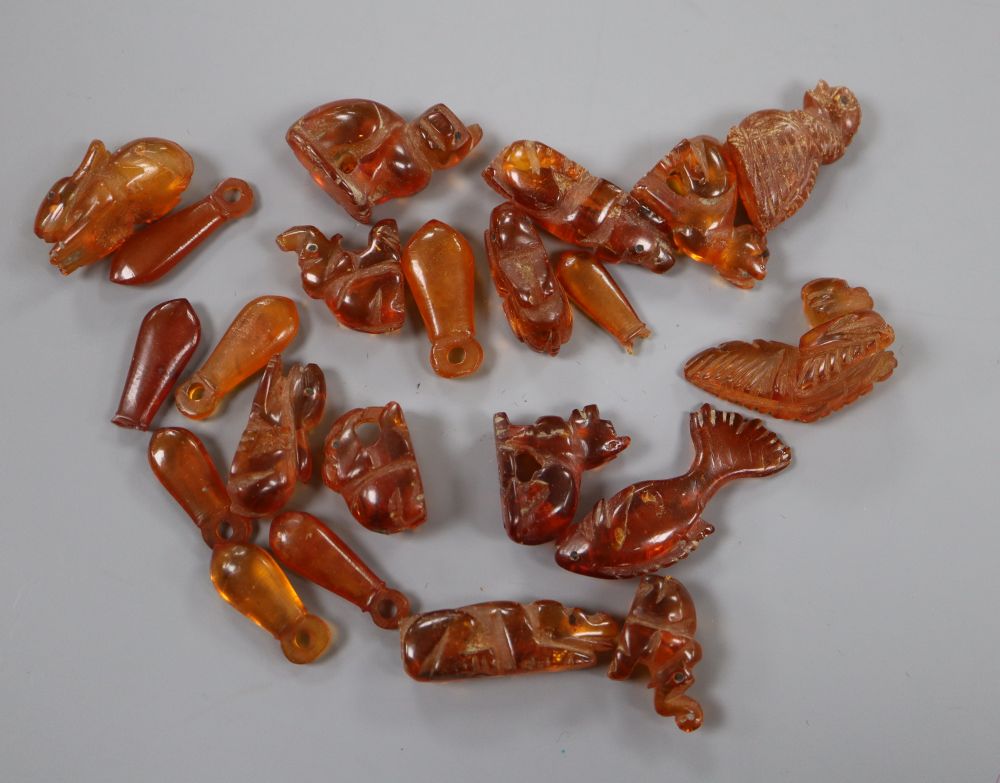 A collection of amber beads, carved as animals, (part of a necklace), largest 31mm, gross 33 grams.